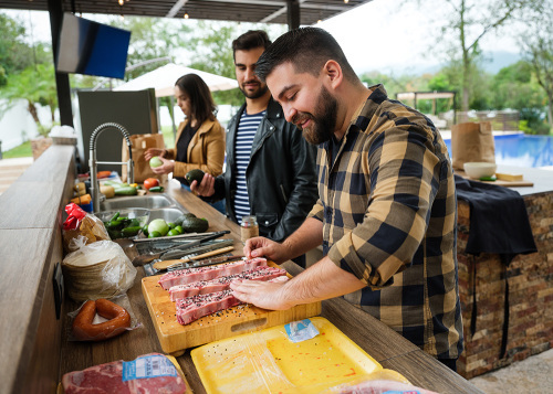 Friends cooking together in outdoor kitchen